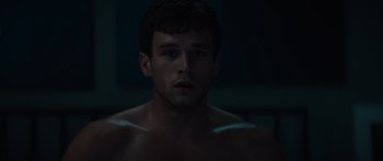 Movie still from “Hellraiser” (2022), directed by David Bruckner – A man with no shirt in a dark room; Close Up shot, High angle