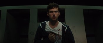 Movie still from “Hellraiser” (2022), directed by David Bruckner – A young man holding a t - shirt with blood on it; Close Up shot, Overhead angle