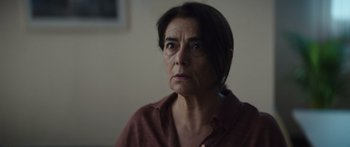 Movie still from “Hellraiser” (2022), directed by David Bruckner – An older woman looking sad while sitting in a room; Close Up shot, Over the shoulder angle