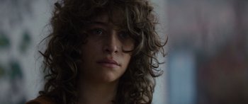 Movie still from “Hellraiser” (2022), directed by David Bruckner – A person with curly brown hair; Close Up shot, Over the shoulder angle