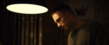 Movie still from “Hellraiser” (2022), directed by David Bruckner – A young man is standing in front of a lamp; Close Up shot, Low angle