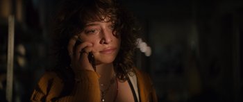 Movie still from “Hellraiser” (2022), directed by David Bruckner – A young woman holding a cell phone up to her ear; Close Up shot, Low angle