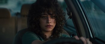 Movie still from “Hellraiser” (2022), directed by David Bruckner – A woman with curly hair sitting in the driver's seat of a car; Close Up shot, Low angle