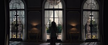 Movie still from “Hellraiser” (2022), directed by David Bruckner – A child standing in front of a window with curtains open; Wide shot, Low angle