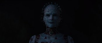 Movie still from “Hellraiser” (2022), directed by David Bruckner – A woman with a face covered in pins; Close Up shot, Low angle