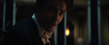 Movie still from “Hellraiser” (2022), directed by David Bruckner – A person wearing a suit and tie; Close Up shot, Over the shoulder angle