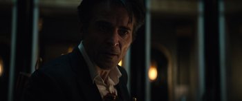 Movie still from “Hellraiser” (2022), directed by David Bruckner – A person wearing a suit and tie; Close Up shot, Over the shoulder angle