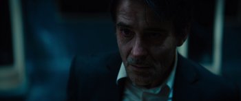 Movie still from “Hellraiser” (2022), directed by David Bruckner – A person wearing a suit and tie; Close Up shot, Over the shoulder angle