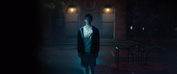 Movie still from “Hellraiser” (2022), directed by David Bruckner – A man standing in the dark in front of a building; Wide shot, High angle