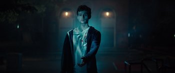 Movie still from “Hellraiser” (2022), directed by David Bruckner – A young man holding something in his hand; Medium shot, Low angle