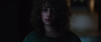 Movie still from “Hellraiser” (2022), directed by David Bruckner – A person with curly hair and blue eyes; Close Up shot, Low angle
