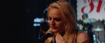 Movie still from “Her Smell” (2018), directed by Alex Ross Perry – A woman with long blonde hair is holding a microphone; Close Up shot, Low angle