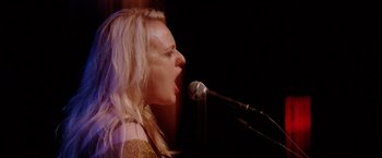 Movie still from “Her Smell” (2018), directed by Alex Ross Perry – A woman with blonde hair is singing into a microphone; Close Up shot, Low angle