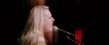 Movie still from “Her Smell” (2018), directed by Alex Ross Perry – A woman is singing into two microphones on a stage; Close Up shot, Low angle