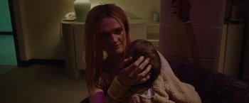Movie still from “Her Smell” (2018), directed by Alex Ross Perry – A woman holding a baby in her arms; Close Up shot, Over the shoulder angle