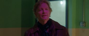 Movie still from “Her Smell” (2018), directed by Alex Ross Perry – A man in a purple jacket is looking at the camera; Close Up shot, Over the shoulder angle