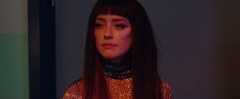 Movie still from “Her Smell” (2018), directed by Alex Ross Perry – A woman with long brown hair wearing a gold dress; Close Up shot, Low angle