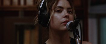 Movie still from “Her Smell” (2018), directed by Alex Ross Perry – A woman wearing headphones and singing into a microphone; Close Up shot, Low angle