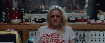 Movie still from “Her Smell” (2018), directed by Alex Ross Perry – A woman with blonde hair wearing a t - shirt; Close Up shot, High angle