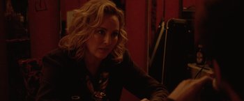 Movie still from “Her Smell” (2018), directed by Alex Ross Perry – A woman sitting at a table with a glass of wine in front of her; Close Up shot, Over the shoulder angle