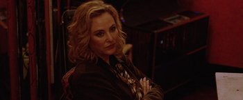 Movie still from “Her Smell” (2018), directed by Alex Ross Perry – A woman with blonde curly hair wearing a suit and tie; Close Up shot, Over the shoulder angle