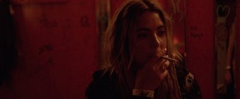 Movie still from “Her Smell” (2018), directed by Alex Ross Perry – A woman is smoking a cigarette in a dark room; Close Up shot, Over the shoulder angle