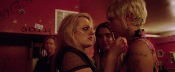 Movie still from “Her Smell” (2018), directed by Alex Ross Perry – A group of people that are standing up together; Close Up shot, Over the shoulder angle