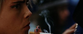 Movie still from “Her Smell” (2018), directed by Alex Ross Perry – A woman is smoking a cigarette with her foot on the table; Extreme Close Up shot, Low angle