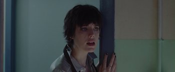 Movie still from “Her Smell” (2018), directed by Alex Ross Perry – A woman with short black hair is leaning against a wall; Close Up shot, Low angle