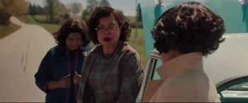 Movie still from “Hidden Figures” (2016), directed by Theodore Melfi – A group of people standing next to each other on a field; Medium shot, Over the shoulder angle