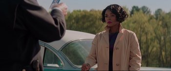 Movie still from “Hidden Figures” (2016), directed by Theodore Melfi – A woman standing next to a car in a parking lot; Medium shot, Over the shoulder angle