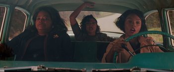 Movie still from “Hidden Figures” (2016), directed by Theodore Melfi – A woman sitting in the back seat of a car with two other women; Medium shot, Low angle