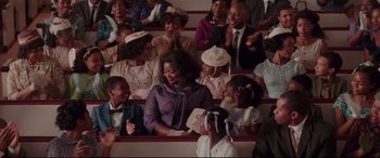 Movie still from “Hidden Figures” (2016), directed by Theodore Melfi – A group of people sitting and standing in a room; Medium shot, High angle