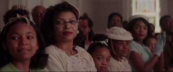 Movie still from “Hidden Figures” (2016), directed by Theodore Melfi – An older woman and a young girl sitting next to each other in front of other people; Close Up shot, Over the shoulder angle