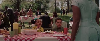 Movie still from “Hidden Figures” (2016), directed by Theodore Melfi – Two children sitting at a picnic table eating food; Medium shot, High angle