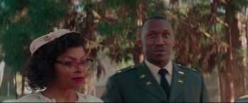 Movie still from “Hidden Figures” (2016), directed by Theodore Melfi – A man and a woman standing next to each other in front of a tree; Medium shot, Over the shoulder angle