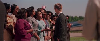 Movie still from “Hidden Figures” (2016), directed by Theodore Melfi – A group of people standing next to each other in a field; Medium shot, Over the shoulder angle