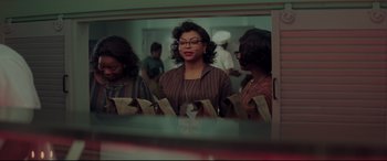 Movie still from “Hidden Figures” (2016), directed by Theodore Melfi – A group of people standing in front of a mirror; Medium shot, Over the shoulder angle