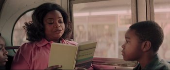 Movie still from “Hidden Figures” (2016), directed by Theodore Melfi – A woman sitting on a train reading a book; Close Up shot, Over the shoulder angle