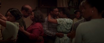 Movie still from “Hidden Figures” (2016), directed by Theodore Melfi – A man and a woman kissing each other in front of other people in a room; Medium shot, Over the shoulder angle