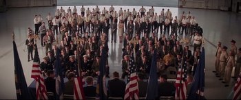 Movie still from “Hidden Figures” (2016), directed by Theodore Melfi – A large group of men in suits and flags; Extreme Wide shot, High angle