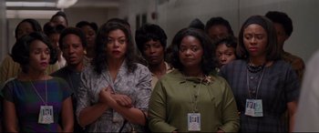 Movie still from “Hidden Figures” (2016), directed by Theodore Melfi – A group of women standing next to each other in a room; Medium shot, High angle