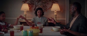Movie still from “Hidden Figures” (2016), directed by Theodore Melfi – A group of people sitting at a table with food; Medium shot, Over the shoulder angle