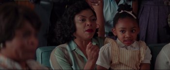 Movie still from “Hidden Figures” (2016), directed by Theodore Melfi – An older black woman sitting next to a young black girl; Close Up shot, Over the shoulder angle