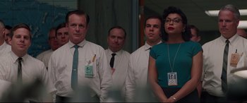 Movie still from “Hidden Figures” (2016), directed by Theodore Melfi – A group of people standing next to each other in a room; Medium shot, Low angle