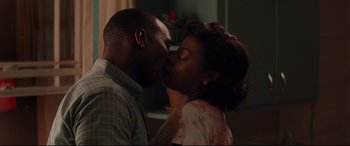 Movie still from “Hidden Figures” (2016), directed by Theodore Melfi – A man and a woman kissing each other in front of a plant; Close Up shot, Low angle