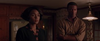 Movie still from “Hidden Figures” (2016), directed by Theodore Melfi – A man and a woman standing next to each other in a room; Medium shot, Low angle