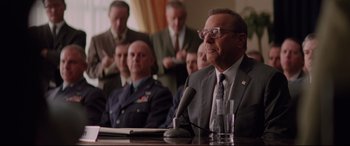 Movie still from “Hidden Figures” (2016), directed by Theodore Melfi – A group of men sitting at a conference table with microphones; Close Up shot, Over the shoulder angle