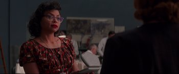 Movie still from “Hidden Figures” (2016), directed by Theodore Melfi – A woman with glasses sitting in front of other people; Medium shot, Over the shoulder angle