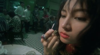 Movie still from “Fallen Angels” (1995), directed by Kar-Wai Wong – A woman is holding a cigarette in her mouth; Close Up shot, High angle